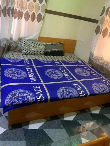a bed with a blue comforter on top of it at AMIGOS HOTEL in Ibadan