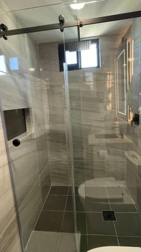 een badkamer met een toilet en een glazen douche bij Luxurious apartment located in the heart of Panama in Panama-Stad