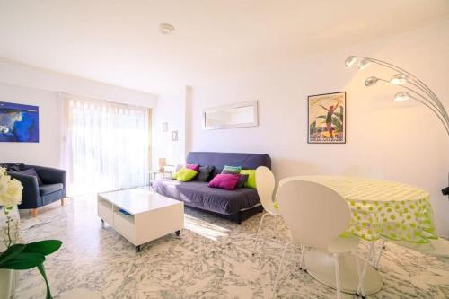 een woonkamer met een bank en een tafel bij Cap les pins furnished flat in Antibes