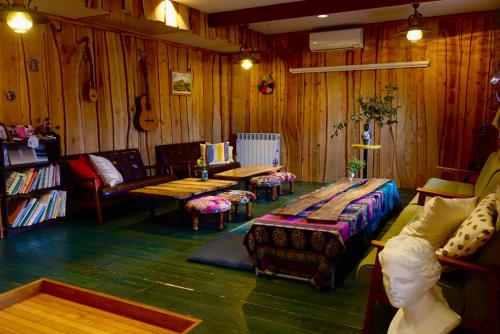 een woonkamer met houten wanden, een bank en een tafel bij Lodge Mondo in Nishina