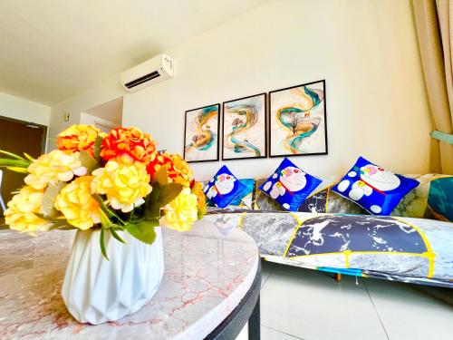 een vaas gevuld met bloemen zittend op een tafel bij Legoland-Happy Wonder Love Suite-Elysia- Max8pax-with Garden-Pool view in Nusajaya
