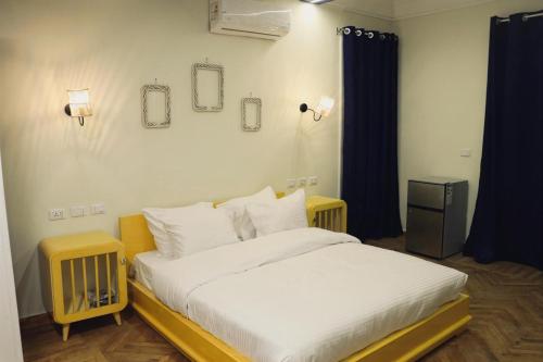 a bedroom with a large bed with white sheets at Town View Studios in Cairo