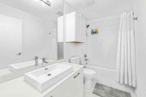 Coral gables apartment في ميامي: حمام أبيض مع حوض ومرحاض
