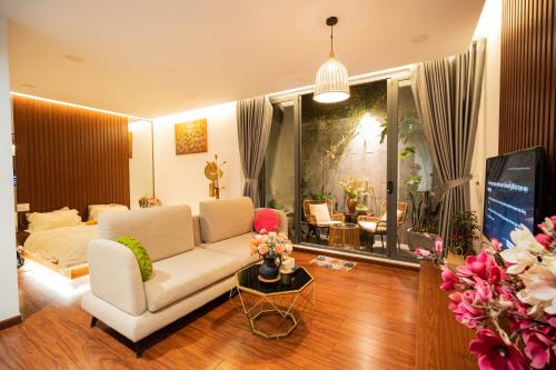 a living room with a white couch and a tv at Homestay My Ny Đà Lạt in Khu Chi Lăng