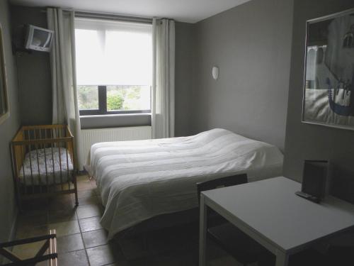 een kleine slaapkamer met een bed en een raam bij Avalon Hotel in Overijse