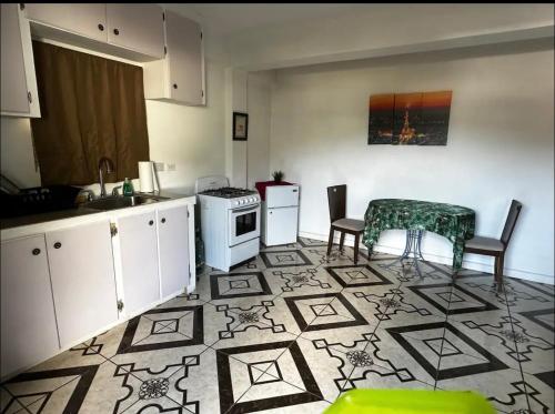 uma cozinha com um fogão, uma mesa e cadeiras em Spacious Home away from Home! 1 Bedroom em Kingstown