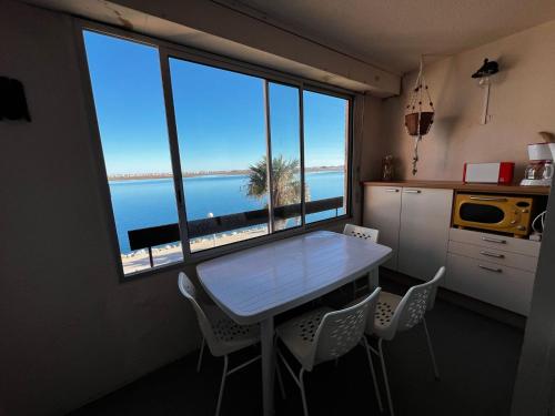 - une table et des chaises dans la cuisine avec vue sur l'océan dans l'établissement Appartement coquet avec parking, 4 couchages - FR-1-784-4, à Gruissan