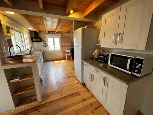 une cuisine avec un réfrigérateur et un plan de travail dans l'établissement Charmant Chalet Rangée 9 avec Wifi, Climatisation et Terrasse - 250m de la Plage, 6 pers - FR-1-784-7, à Gruissan