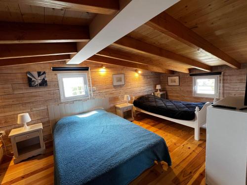 une chambre avec un lit dans une pièce aux murs en bois dans l'établissement Charmant Chalet Rangée 9 avec Wifi, Climatisation et Terrasse - 250m de la Plage, 6 pers - FR-1-784-7, à Gruissan