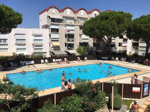 une grande piscine devant un immeuble dans l'établissement Studio cosy avec piscine, parking et balcon à Gruissan - FR-1-784-13, à Gruissan