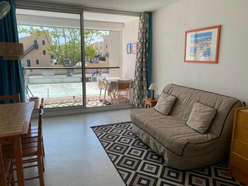 un salon avec un canapé et une table dans l'établissement Studio cosy avec piscine, parking et balcon à Gruissan - FR-1-784-13, à Gruissan