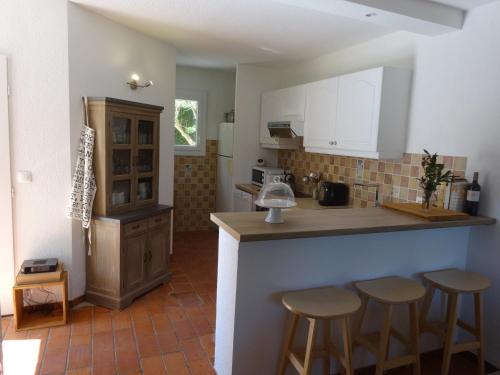 - une cuisine avec un comptoir et des tabourets dans l'établissement Maison 3 chambres avec terrasses, jardinet, climatisation et Wifi, proche port et plage à Gruissan - FR-1-784-9, à Gruissan