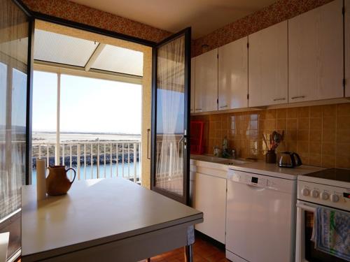 une cuisine avec une table et une vue sur l'océan dans l'établissement Chalet individuel 6-7 pers avec barbecue, terrasse, parking, animaux admis à Gruissan - FR-1-784-18, à Gruissan