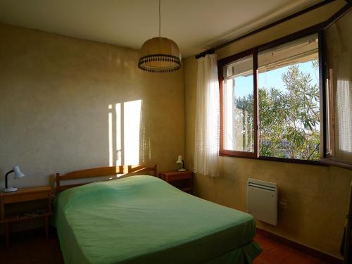 une chambre avec un lit vert et une fenêtre dans l'établissement Chalet individuel 6-7 pers avec barbecue, terrasse, parking, animaux admis à Gruissan - FR-1-784-18, à Gruissan