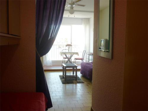 un salon avec une table et une fenêtre dans l'établissement Studio cosy avec loggia et parking privé - Proche port et commerces - FR-1-784-19, à Gruissan