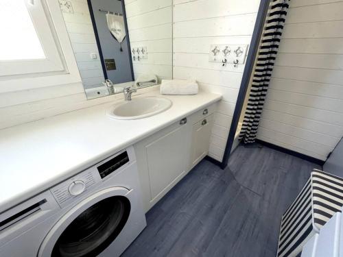 a bathroom with a washing machine and a sink at Chalet Gruissan, 4 pièces, 8 personnes - FR-1-784-21 in Gruissan