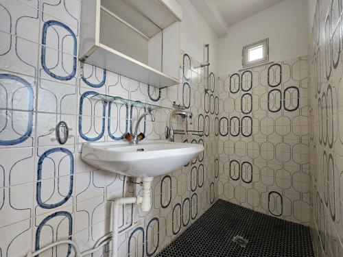 La salle de bains est pourvue d'un lavabo blanc et de carrelage bleu et blanc. dans l'établissement Charmant Appartement Proche Plage - 4 Pers - Animaux sur Demande - Wifi Gratuite - FR-1-476-211, à La Faute-sur-Mer