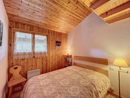 une chambre avec un lit et un plafond en bois dans l'établissement Appartement avec garage proches ski bus à Combloux - FR-1-560-126, à Combloux