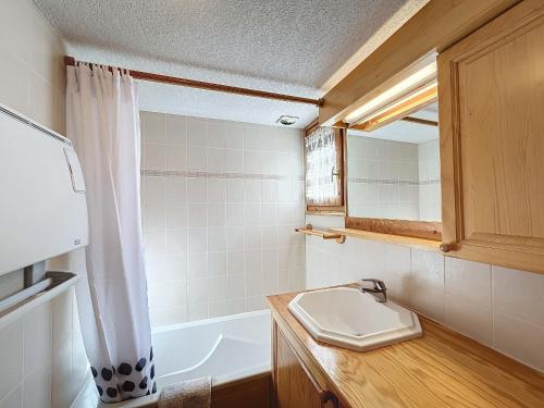 une salle de bain avec un lavabo, une baignoire et un miroir dans l'établissement Appartement avec garage proches ski bus à Combloux - FR-1-560-126, à Combloux