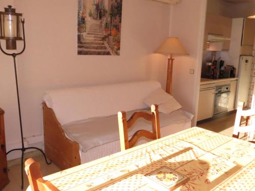 Cette chambre comprend une table, un lit et une cuisine. dans l'établissement Appartement 2 pièces climatisé, calme, proche centre-ville et plage, avec balcon - Sainte-Maxime - FR-1-780-78, à Sainte-Maxime