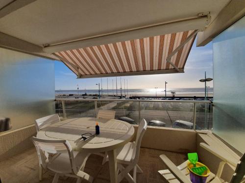 un balcon avec une table et des chaises et une vue sur la plage dans l'établissement Appartement rénové 3 pièces, 6 couchages avec balcon, TV et parking sécurisé - Saint-Jean-de-Monts - FR-1-224C-291, à Saint-Jean-de-Monts
