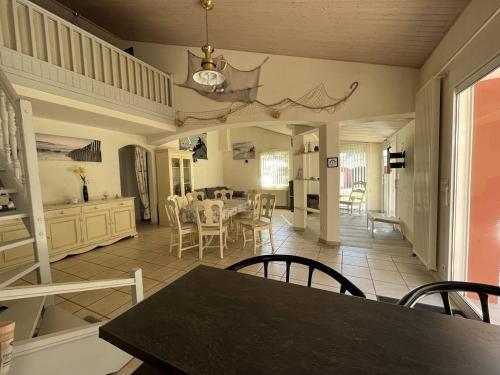 une salle à manger et une cuisine avec une table et des chaises dans l'établissement Grande Maison 12 Pers. avec Terrasse, Proche Plage et Forêt, Animaux Admis - FR-1-324A-61, à Saint-Jean-de-Monts