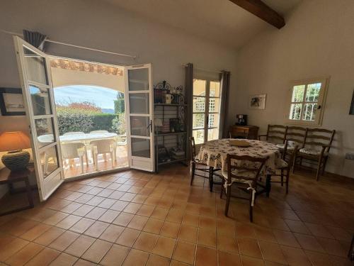 une salle à manger avec une table, des chaises et une porte ouverte dans l'établissement Maison Individuelle 2 Chambres avec Jardin, Piscine et Tennis, Proche du Centre-Village - FR-1-726-44, à La Croix-Valmer