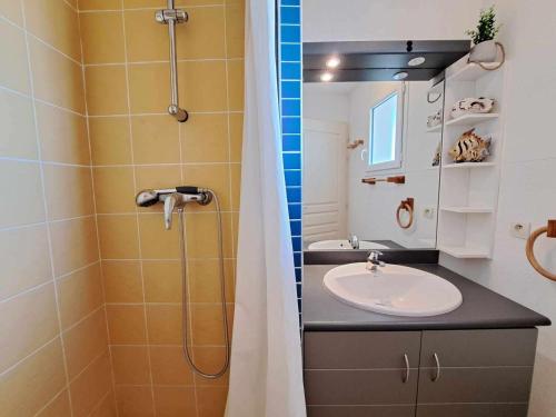 une salle de bain avec un lavabo et une douche dans l'établissement Appartement 2 pièces avec terrasse, parking et accès direct à la plage à Marseillan - FR-1-326-816, à Marseillan