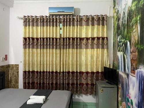 a room with a bed and a curtain at Khách sạn Hoàng Bảo Hùng in Ho Chi Minh City