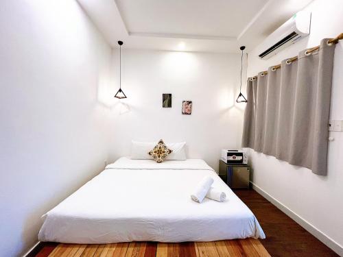 a bedroom with a white bed with white sheets at Maison Bùi Viện in Ho Chi Minh City