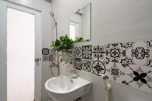 uma casa de banho com um lavatório e um espelho em Maison Bùi Viện em Ho Chi Minh
