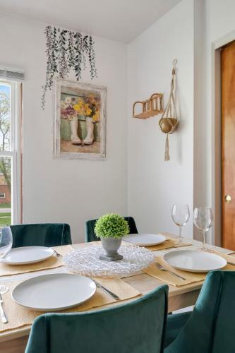 a dining room table with white plates and chairs at Cozy Getaway for Long-Term Stays in Westmont