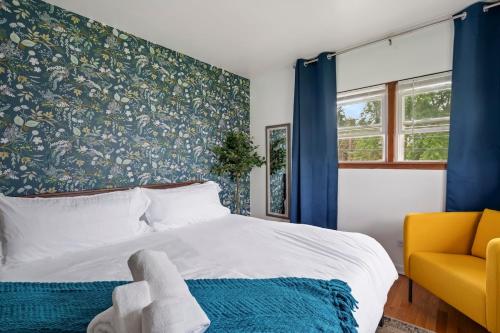 a bedroom with a large bed and a yellow chair at Cozy Getaway for Long-Term Stays in Westmont