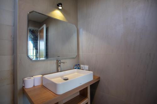 a bathroom with a white sink and a mirror at Griya D'Carik in Perean