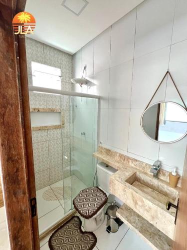 een badkamer met een toilet en een glazen douche bij Casa em Paripueira, conforto e privacidade in Paripueira