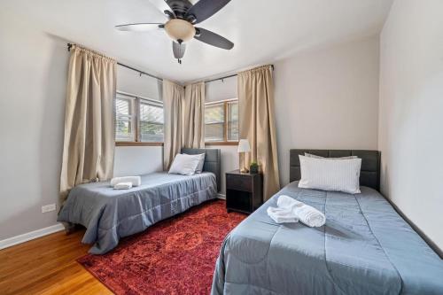 una camera da letto con due letti e un ventilatore a soffitto di Harmony Haven a Westmont