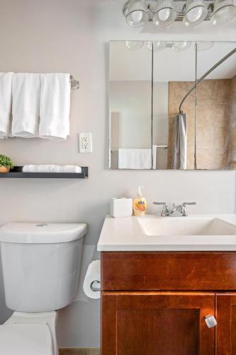 a bathroom with a toilet and a sink and a mirror at Harmony Haven in Westmont