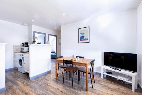une cuisine et une salle à manger avec une table et une télévision dans l'établissement Appartement T3 - 2 chambres 4 personnes - Centre Ville St Nazaire - Au calme, à Saint-Nazaire
