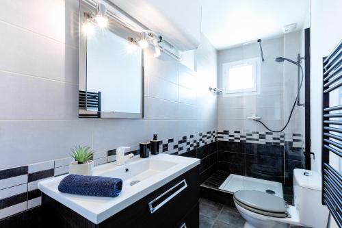 une salle de bain avec un lavabo, des toilettes et une douche dans l'établissement Appartement T3 - 2 chambres 4 personnes - Centre Ville St Nazaire - Au calme, à Saint-Nazaire