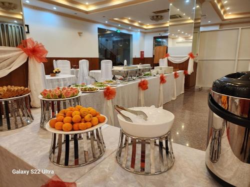 ein Buffet mit Orangen und anderen Früchten auf dem Tisch in der Unterkunft Paradis Hotel Quy Nhon in Quy Nhon