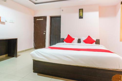a bedroom with a large bed with red pillows at SPOT ON Hotel Sunshine Inn in Hyderabad