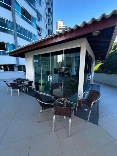 a group of chairs and tables on a building at Loft em prédio frente mar in Balneário Camboriú