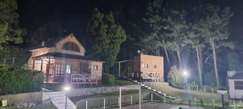 a large wooden house at night with trees at CasaAlpina in Tandil