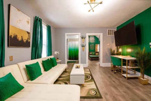 a living room with a white couch and green walls at The Tremont Emerald - By Christmas Story House - Historic Charm & Modern Comfort Near Downtown With Parking, 300MB Wifi & Self Check-In in Cleveland