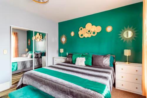 a bedroom with a large bed with a green wall at The Tremont Emerald - By Christmas Story House - Historic Charm & Modern Comfort Near Downtown With Parking, 300MB Wifi & Self Check-In in Cleveland