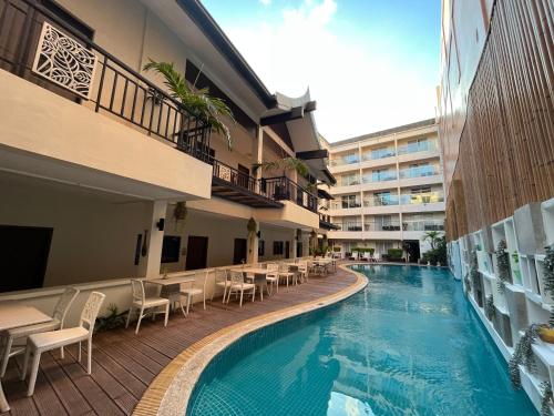 a hotel swimming pool with tables and chairs next to a building at Boracay Haven Resort in Boracay