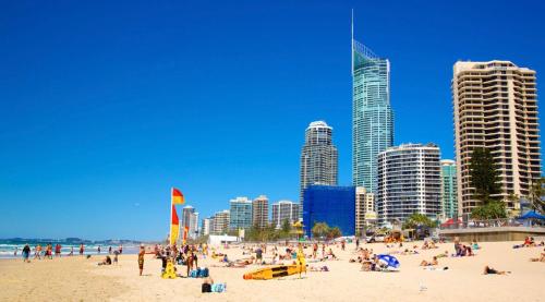 a group of people on a beach with tall buildings at Deluxe Queen Studio Fully Self Contained- Living, kitchenette, laundry, bedroom, bathroom, parking, Wifi, - Free shuttle Service in Gold Coast