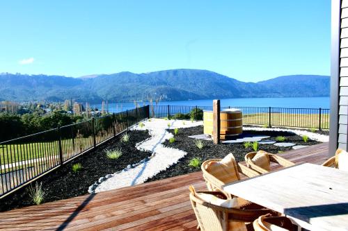 a deck with a table and chairs and a view of the water at Kinloch Lake View in Kinloch