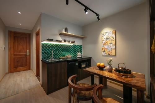 cocina con mesa de madera y encimera en Brilliant Nature Suites & Spa, en Hanói