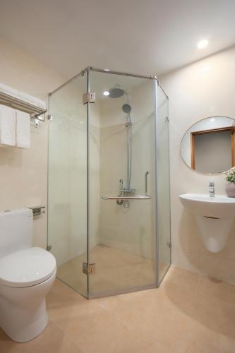 a bathroom with a shower and a toilet and a sink at Brilliant Nature Suites & Spa in Hanoi